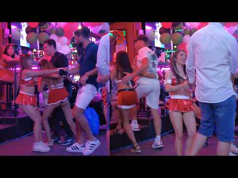 Thai Girls pull western men to the Beer Bar. Soi 6 Pattaya,Thailand. Christmas 2024.
